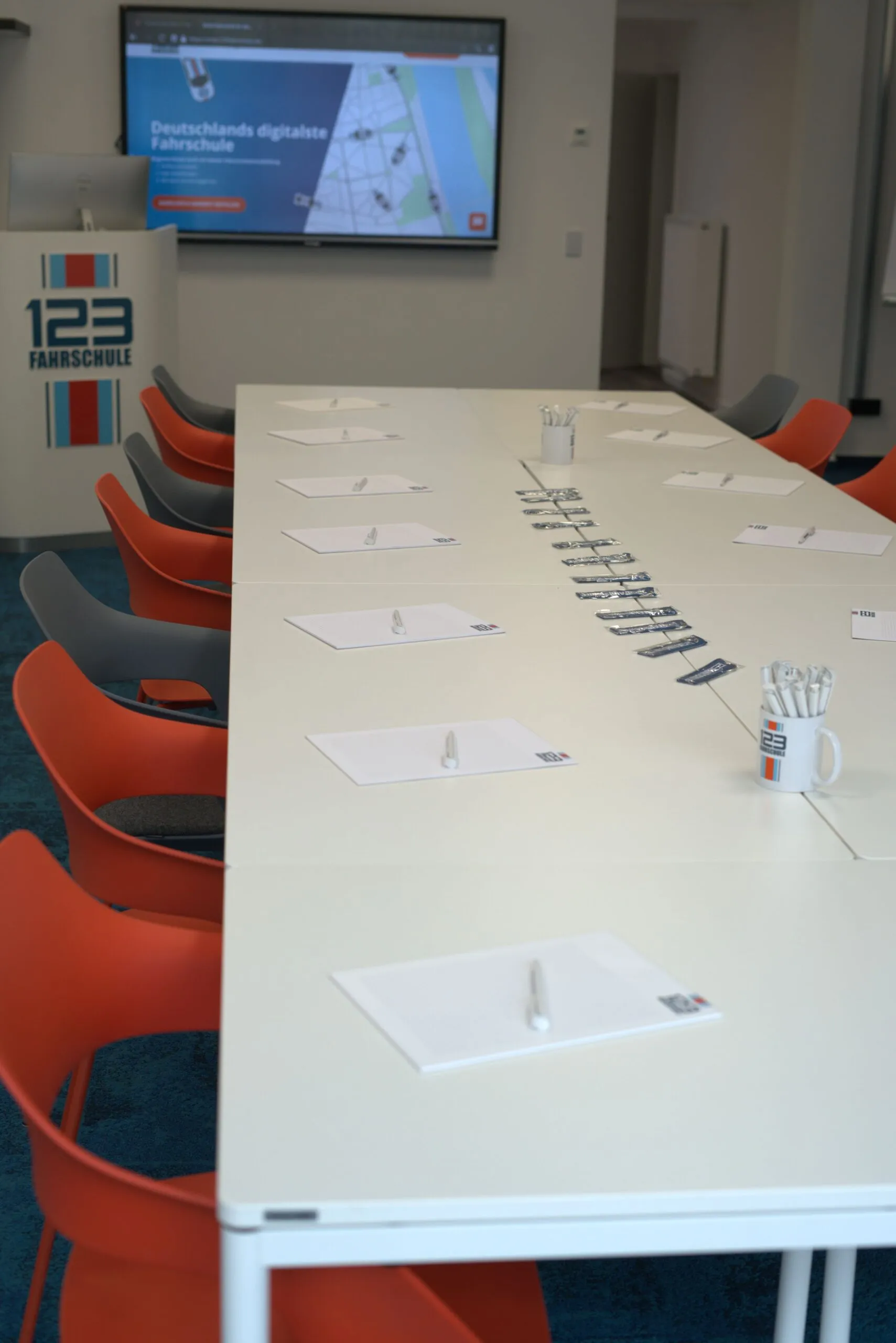 Raum für den Theorieunterricht der 123 Fahrschule mit einem sehr großen Tisch